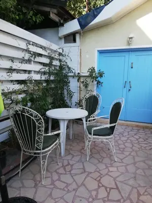 a patio with a table and chairs and a garage at Swallows Nest in Larnaka