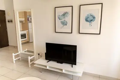 a living room with a flat screen tv on a wall at Blue Dawn Center Flat in Larnaka