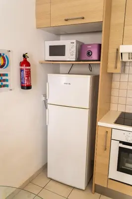 a small kitchen with a white refrigerator and a microwave at Blue Dawn Center Flat in Larnaka
