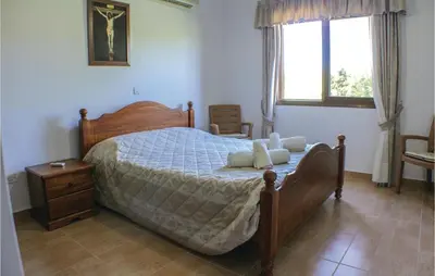 a bedroom with a large bed and a window at Stunning Home In Maroni-Larnaca in Pervolia