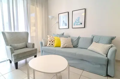 a living room with a blue couch and a chair at Violet Dusk City Center Flat in Larnaka