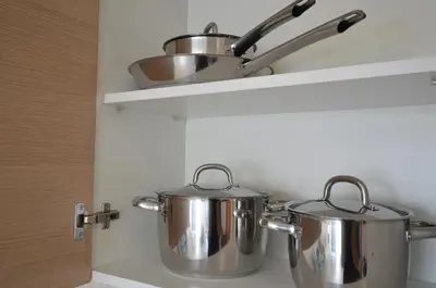 two pots and pans on a shelf in a kitchen at Violet Dusk City Center Flat in Larnaka
