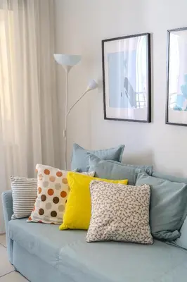 a blue couch with pillows on it in a living room at Violet Dusk City Center Flat in Larnaka