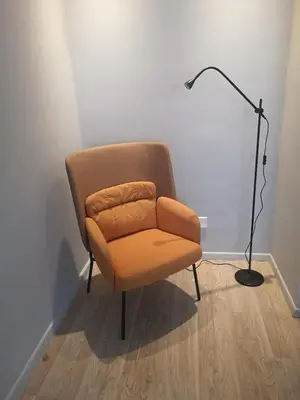 an orange chair in a room with a lamp at Beachfront Amazing New Apartment in Limassol