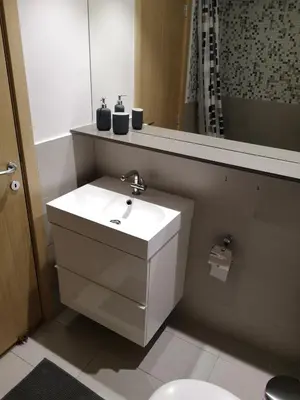 a bathroom with a white sink and a mirror at Beachfront Amazing New Apartment in Limassol