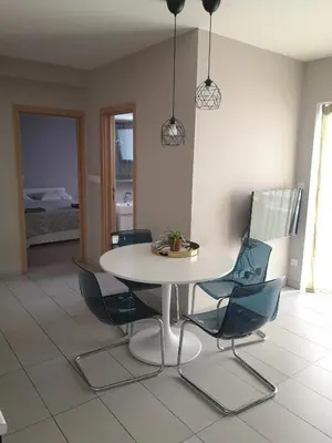 a dining room with a white table and chairs at Beachfront Amazing New Apartment in Limassol