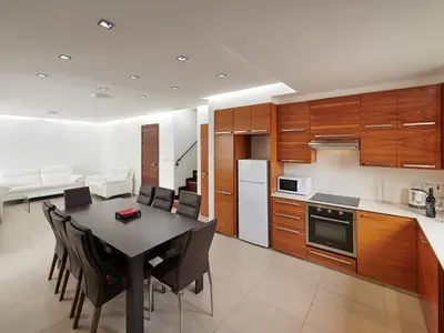 a kitchen and dining room with a table and chairs at Angie Luxury Beach Villas in Ayia Napa