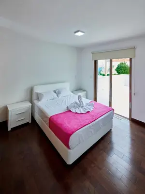 a bedroom with a large bed with a pink blanket at Angie Luxury Beach Villas in Ayia Napa