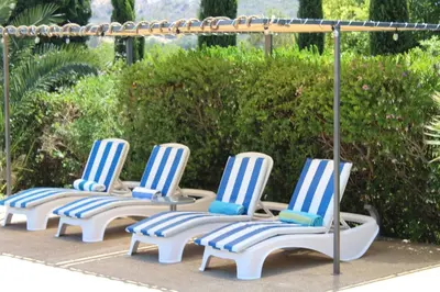 four lounge chairs are lined up in a row at St.George's Country Retreat in Limassol