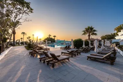 a group of chairs and umbrellas on a patio at Adelais Bay Hotel in Protaras