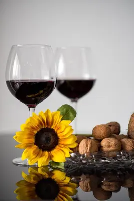 two glasses of wine and flowers and nuts on a table at Mesogios House Suites in Larnaka