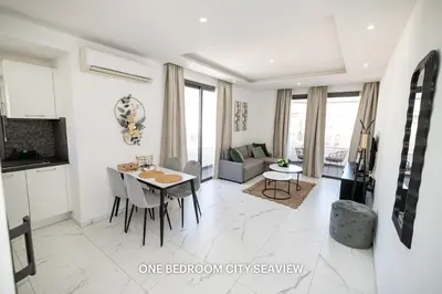 a kitchen and living room with a table and chairs at Lazuli Seaview Apartments 2Bdr in Larnaka