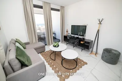 a living room with a couch and a tv at Lazuli Seaview Apartments 2Bdr in Larnaka