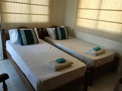 two twin beds in a room with windows at Villa Emiliana in Paralimni