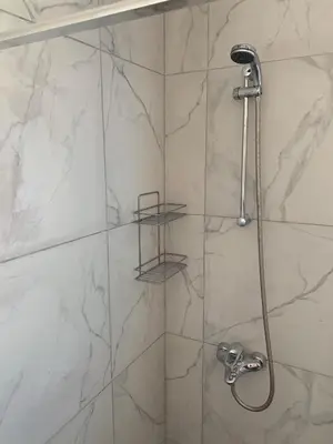 a bathroom with a shower with white marble walls at Villa Emiliana in Paralimni
