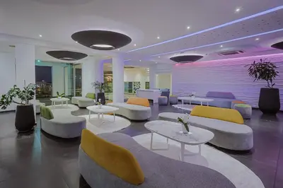 a lobby with couches and tables and chairs at Tasia Maris Oasis in Ayia Napa
