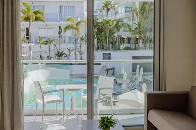 a room with a balcony with a table and chairs at Tasia Maris Oasis in Ayia Napa