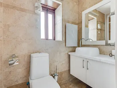 a bathroom with a toilet and a sink and a mirror at Arsorama Village Homes in Arsos