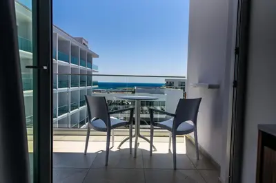 a balcony with a table and chairs and the ocean at Eleana Hotel in Ayia Napa