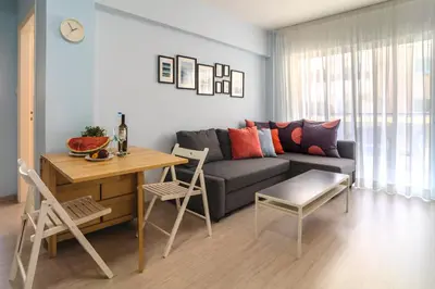a living room with a couch and a table at Helios Mackenzie One Bedroom Flat in Larnaka