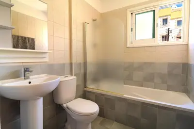 a bathroom with a toilet and a sink and a shower at Helios Mackenzie One Bedroom Flat in Larnaka