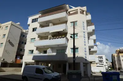 a white van parked in front of a building at Helios Mackenzie One Bedroom Flat in Larnaka