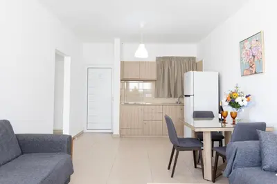 a living room with a table and a refrigerator at Christothea Apartments in Ayia Napa