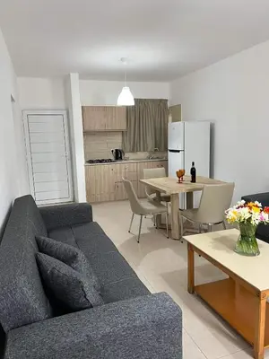 a living room with a couch and a table and a kitchen at Christothea Apartments in Ayia Napa