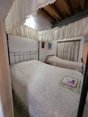 a bedroom with two beds with white sheets and a window at Christiana's stone studios in Pano Lefkara