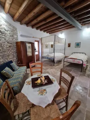a living room with a table and a bed at Christiana's stone studios in Pano Lefkara