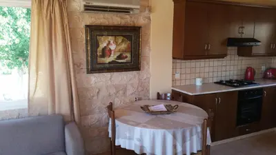 a kitchen with a table in a kitchen with a window at Kotzias Beach Apartments in Pissouri