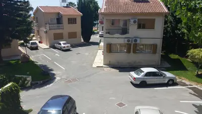 a car parked in a parking lot in front of a house at Kotzias Beach Apartments in Pissouri
