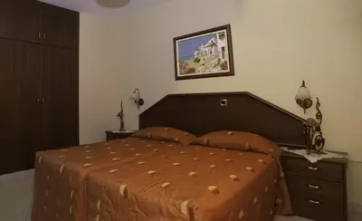 a bedroom with a bed and a dresser and a picture at Kotzias Beach Apartments in Pissouri