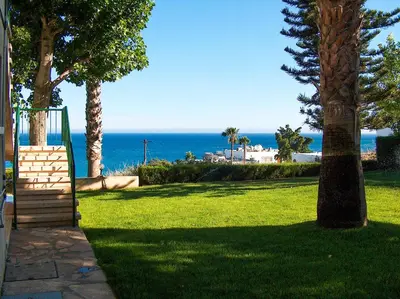 a view of the ocean from a park with a playground at Kotzias Beach Apartments in Pissouri