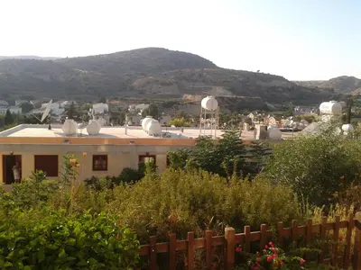 a view of a house with a mountain in the background at Pelekanos Apartments in Pissouri