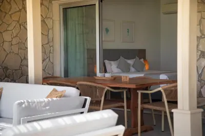 a room with a bed and a table and chairs at Elya Beach Luxury Suites in Ayios Theodhoros
