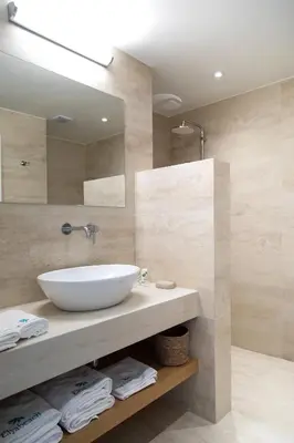 a bathroom with a white sink and a mirror at Elya Beach Luxury Suites in Ayios Theodhoros