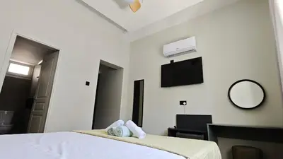a bedroom with a bed with towels and a tv at St Lazarus City Hotel in Larnaka