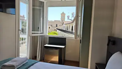 a bedroom with a window with a laptop on a desk at St Lazarus City Hotel in Larnaka