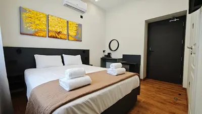 a bedroom with a bed with two towels on it at St Lazarus City Hotel in Larnaka