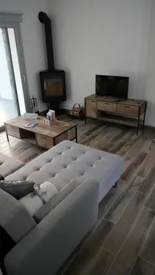 a living room with a couch and a table and a tv at Evmelia Kakopetria Suites in Kakopetria