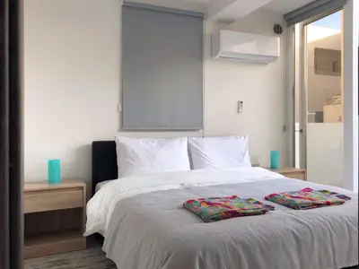 a bedroom with a white bed with two pillows on it at Ayia Napa GO SEA Sunny Apt with Terrace 5 min to Beach in Ayia Napa