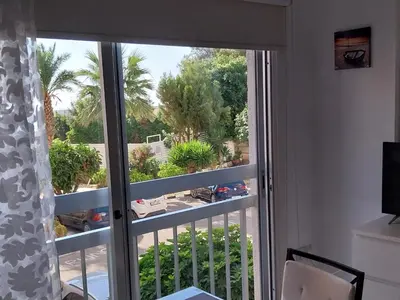 a sliding glass door with a view of a yard at Stelia's Seagate Studio Apt. in Larnaka