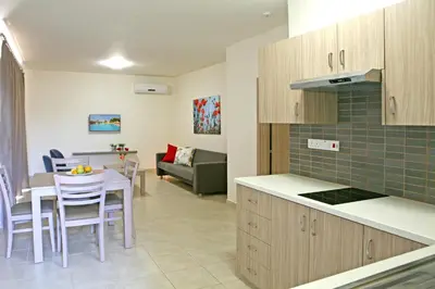 a kitchen and living room with a table and chairs at Makronisos Village in Ayia Napa