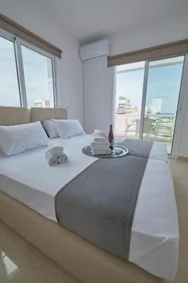 a large white bed with a tray of towels on it at FIG TREE GIANNIS in Protaras