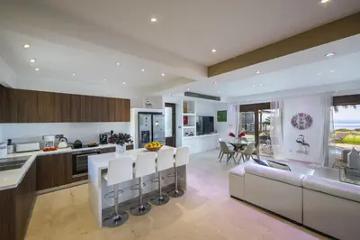 a kitchen and living room with a table and chairs at Protaras El Greco Seafront Villa, Greco Mare in Protaras