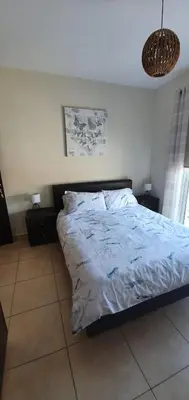 a bedroom with a bed with a blue comforter at Kapparis Apartment Mythical Sands in Protaras