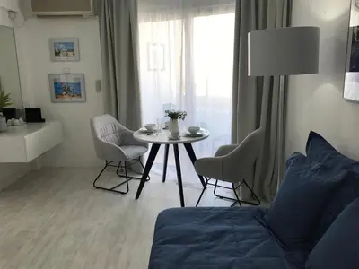 a living room with a table and chairs and a couch at Sea View Holiday Apartment in Larnaka