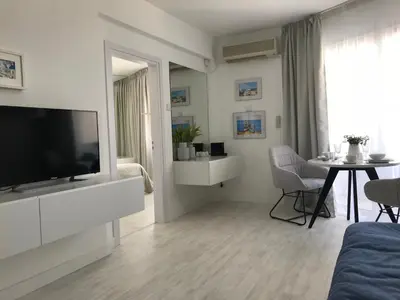 a living room with a television and a dining table at Sea View Holiday Apartment in Larnaka