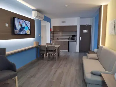 a living room with a couch and a dining room at Melini Hotel Suites in Protaras